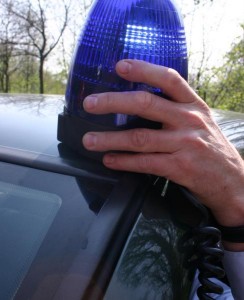Policeman putting a light on his car.